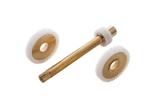 Zahnrad und Welle aus Messing, umgeben von weißen Kunststoffzahnrädern, gehören zu einem Ideal Standard Produkt für mechanische Anwendungen.